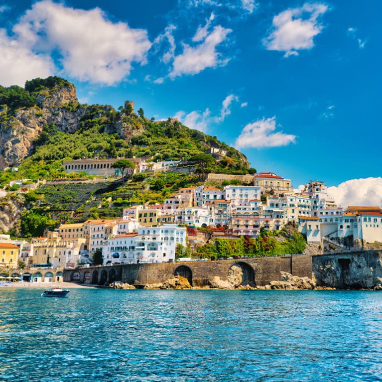 Vista di un pittoresco villaggio costiero con case colorate e mare azzurro.